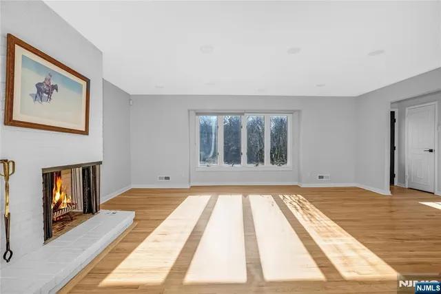 a view of an empty room with window and a fireplace