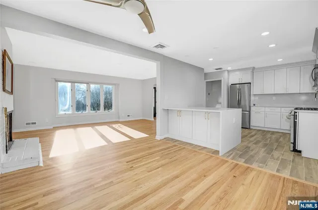 a view of empty room with wooden floor and window