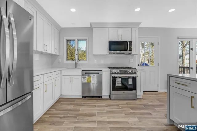 a kitchen with stainless steel appliances a refrigerator sink and microwave