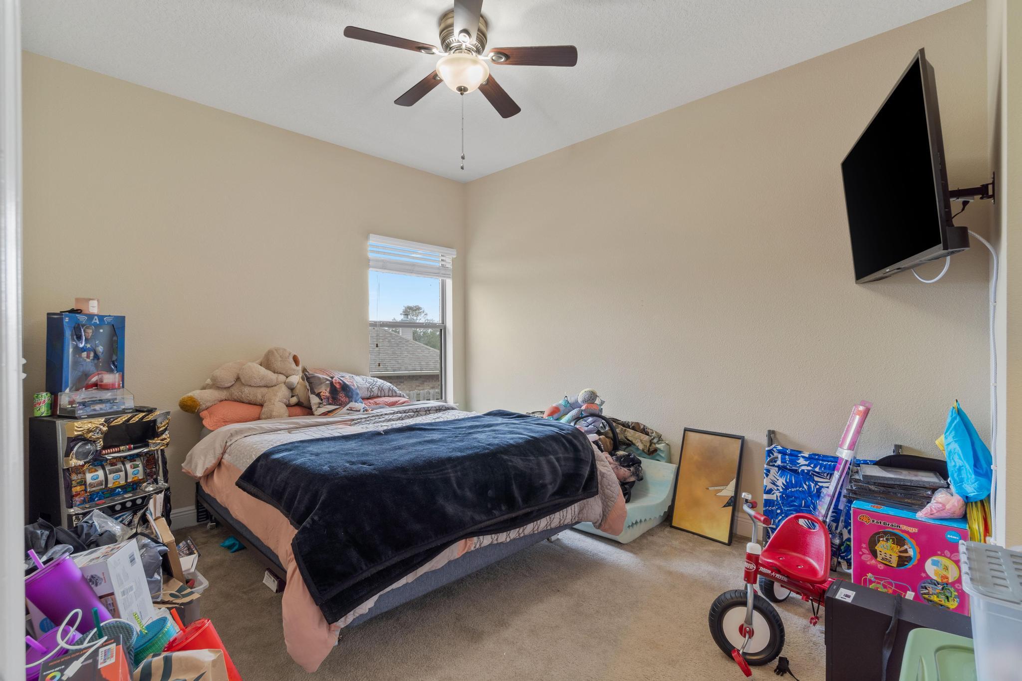 641 Red Fern Road Crestview, FL 32536 - Photo 11 of 33 a bedroom with a bed and flat screen tv