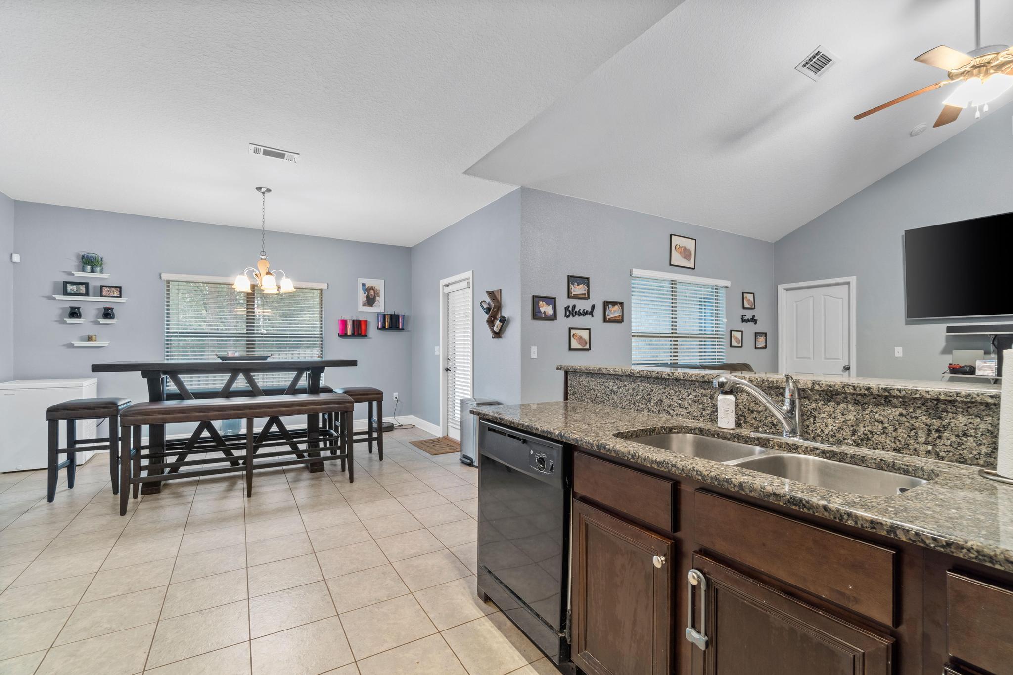 641 Red Fern Road Crestview, FL 32536 - Photo 20 of 33 a kitchen with granite countertop sink table and chairs