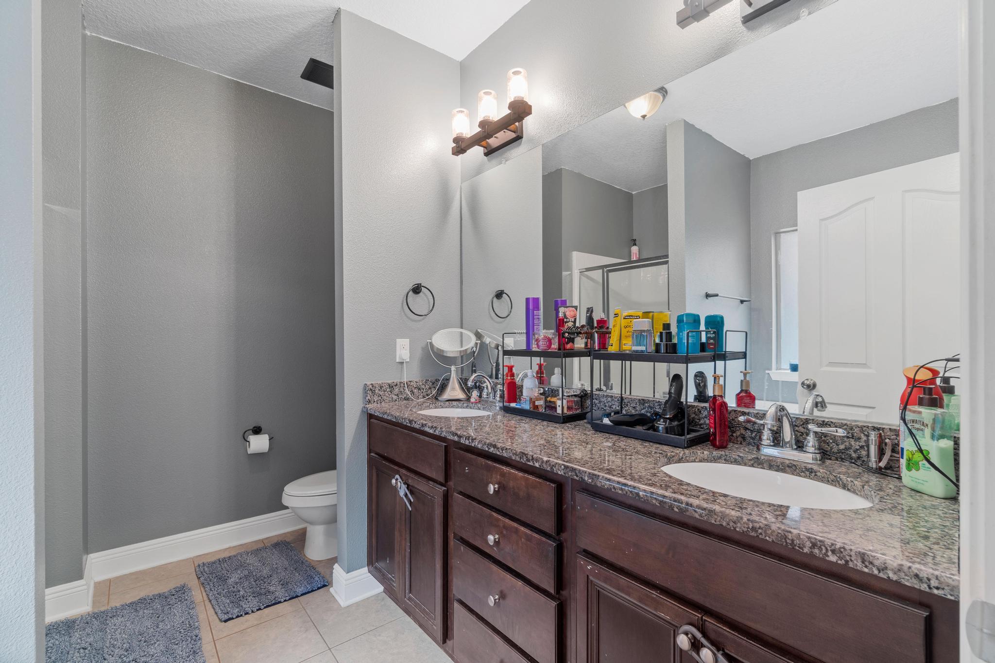 641 Red Fern Road Crestview, FL 32536 - Photo 24 of 33 a bathroom with a granite countertop sink a toilet and mirror