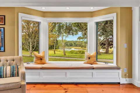 a view of a hallway with wooden floor and windows with fireplace