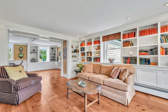 a living room with furniture a fireplace and a floor to ceiling window