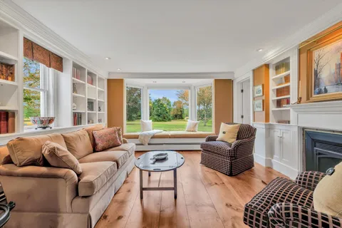 a living room with fireplace furniture and a floor to ceiling window