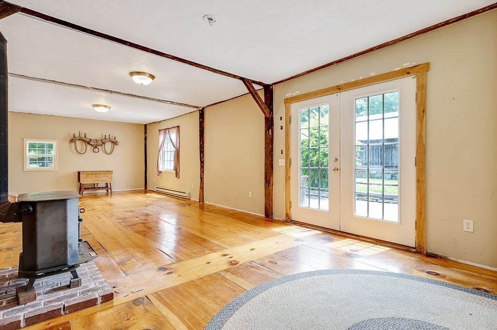 67 Stone School Road Sutton, MA 01590 - Photo 6 of 41 a view of an empty room with a window and a kitchen