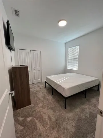 a bedroom with a bed and a television in it