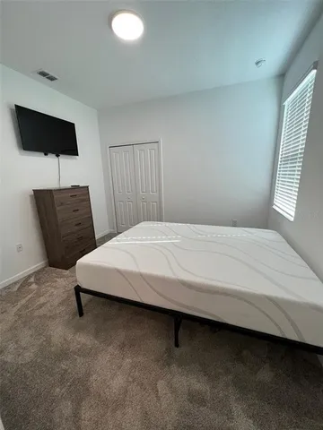 a bedroom with a bed and a chair