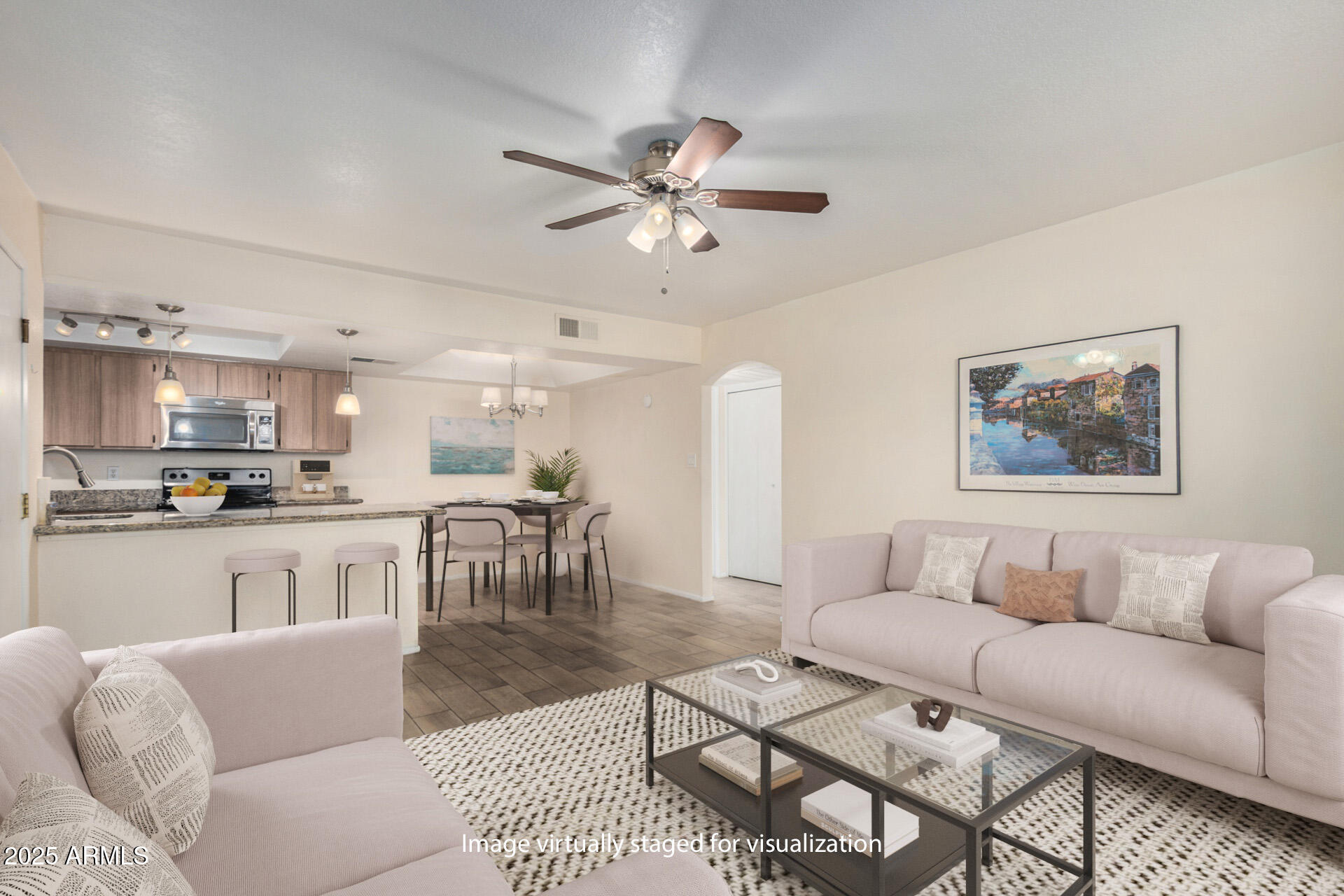 a living room with furniture kitchen view and a chandelier