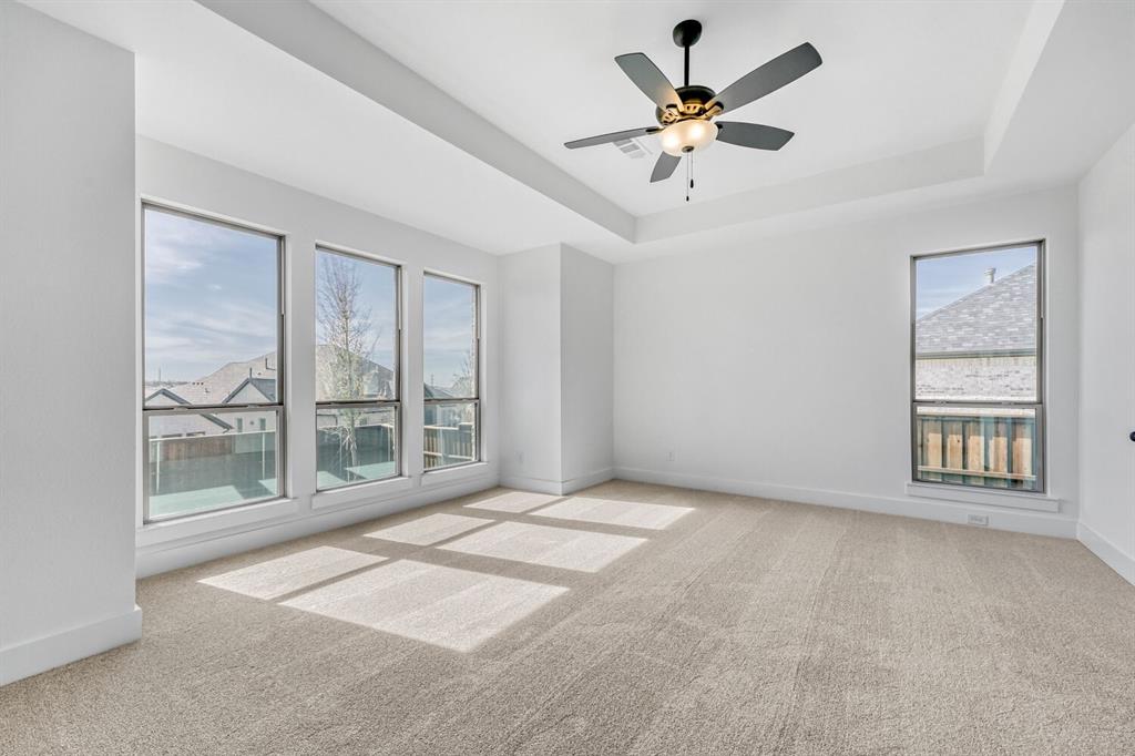 147 Derrett Lane Rhome, TX 76078 - Photo 14 of 28 Unfurnished room with light colored carpet, ceiling fan, and a tray ceiling
