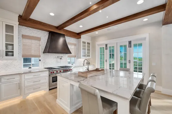 a kitchen with stainless steel appliances granite countertop a sink a stove and a wooden floors