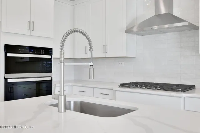 a kitchen with granite countertop a sink and a stove