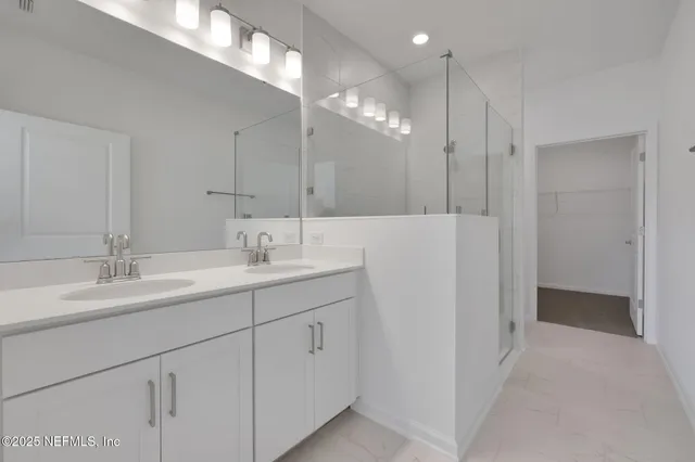 a bathroom with a double vanity sink mirror and shower