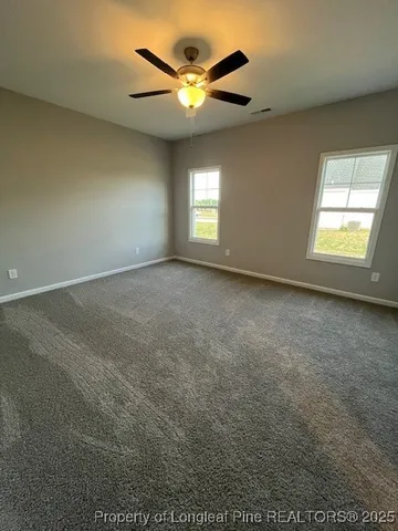 an empty room with a window and a ceiling fan