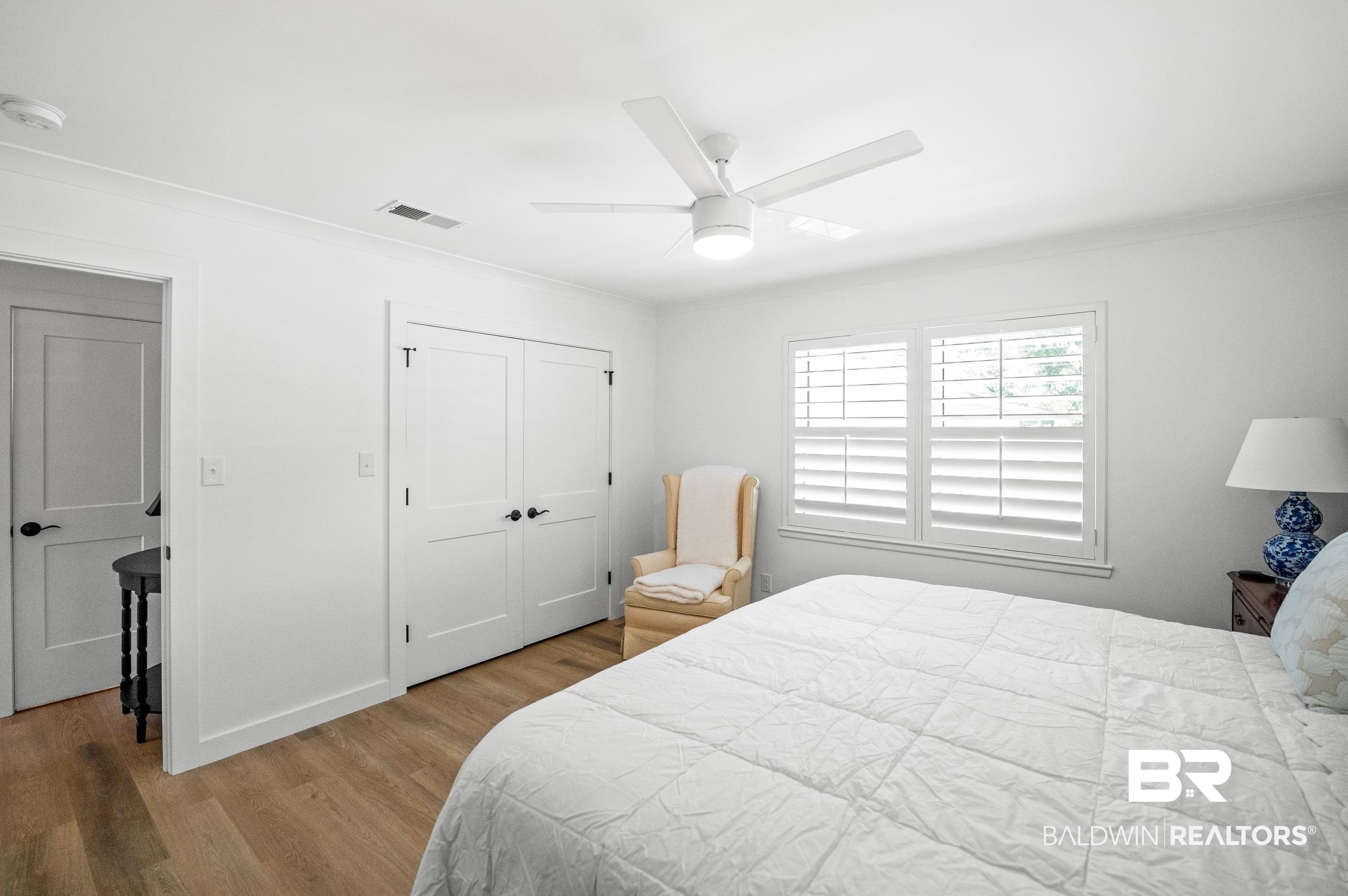 9459 Soldier Creek Road Lillian, AL 36549 - Photo 16 of 54 Bedroom with wood finished floors, a ceiling fan, visible vents, baseboards, and a closet