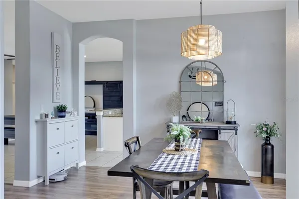 a view of a dining room with furniture a chandelier and wooden floor