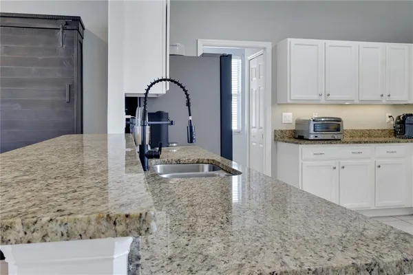 a kitchen with granite countertop a sink and cabinets
