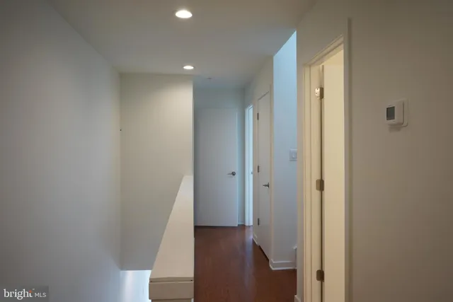 a view of a hallway with wooden floor