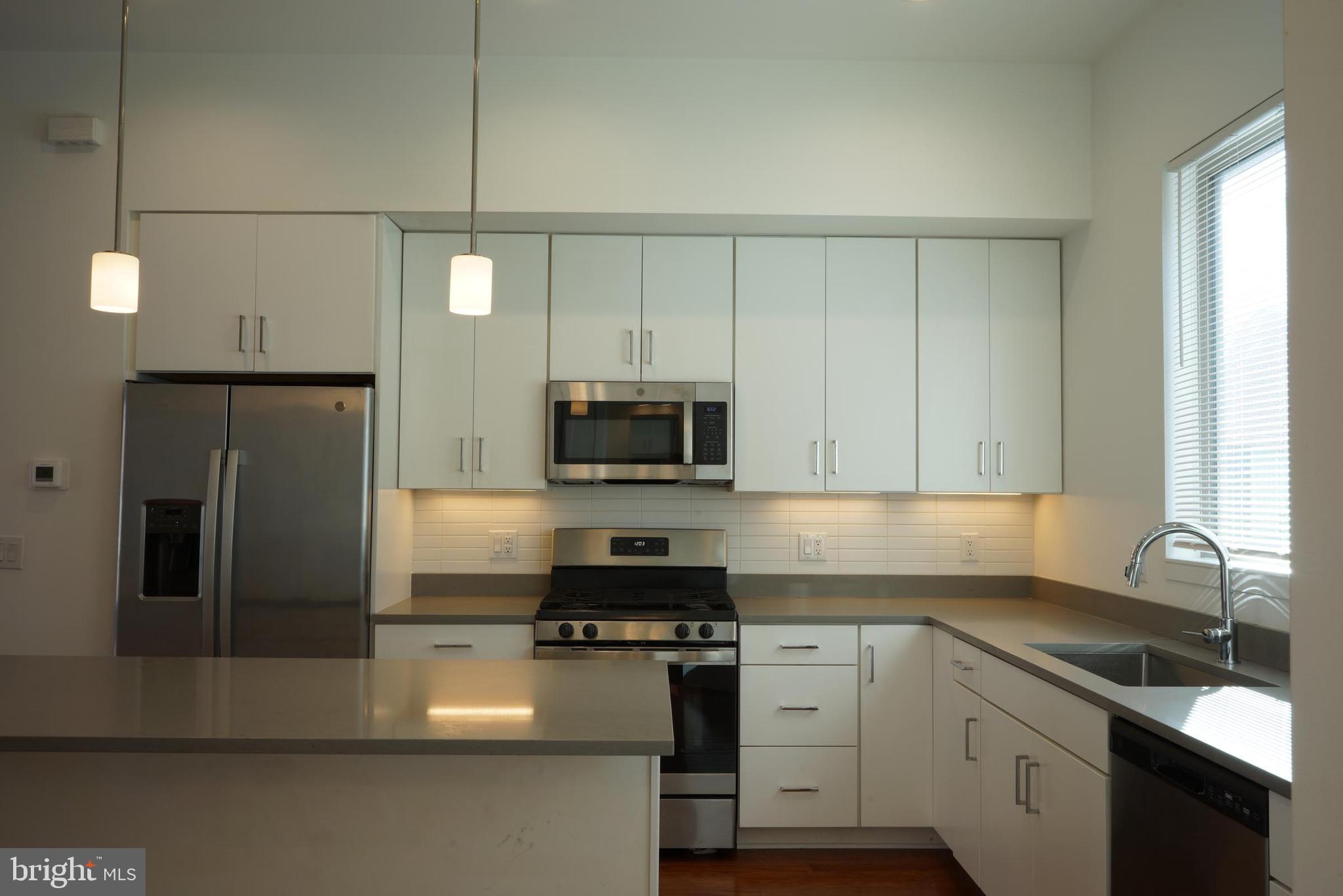 3130 Pierview Lane Philadelphia, PA 19125 - Photo 6 of 26 a kitchen with a sink a microwave a refrigerator and cabinets