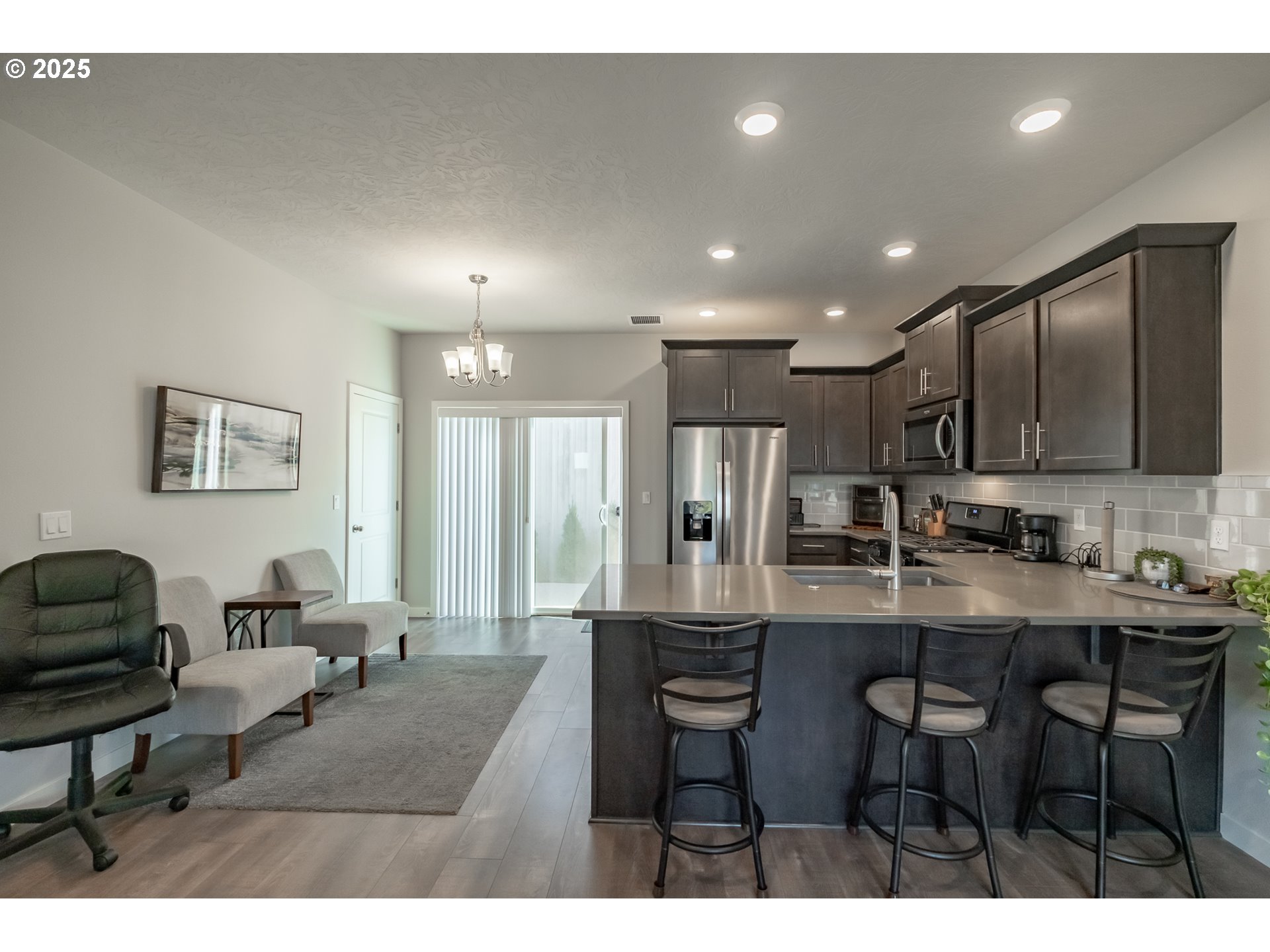 4465 Ninebark Loop Sweet Home, OR 97386 - Photo 2 of 23 a kitchen with stainless steel appliances kitchen island granite countertop a dining table chairs and a refrigerator