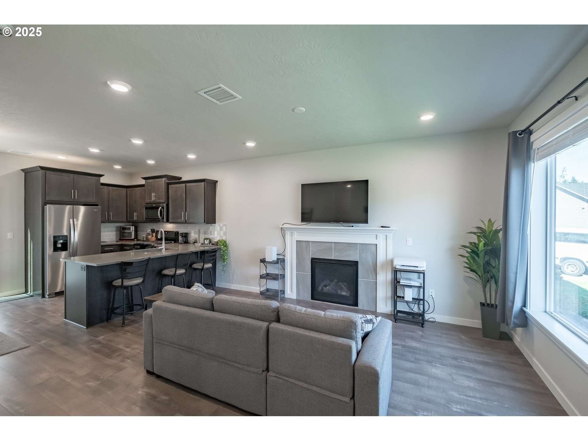 4465 Ninebark Loop Sweet Home, OR 97386 - Photo 3 of 23 a living room with stainless steel appliances furniture a fireplace a flat screen tv and a window