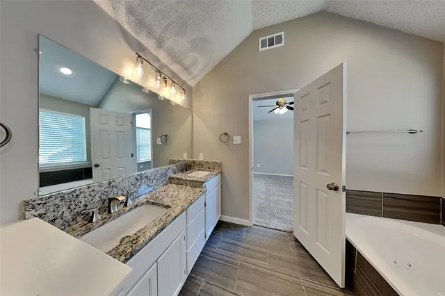 a bathroom with a double vanity sink a mirror and a shower