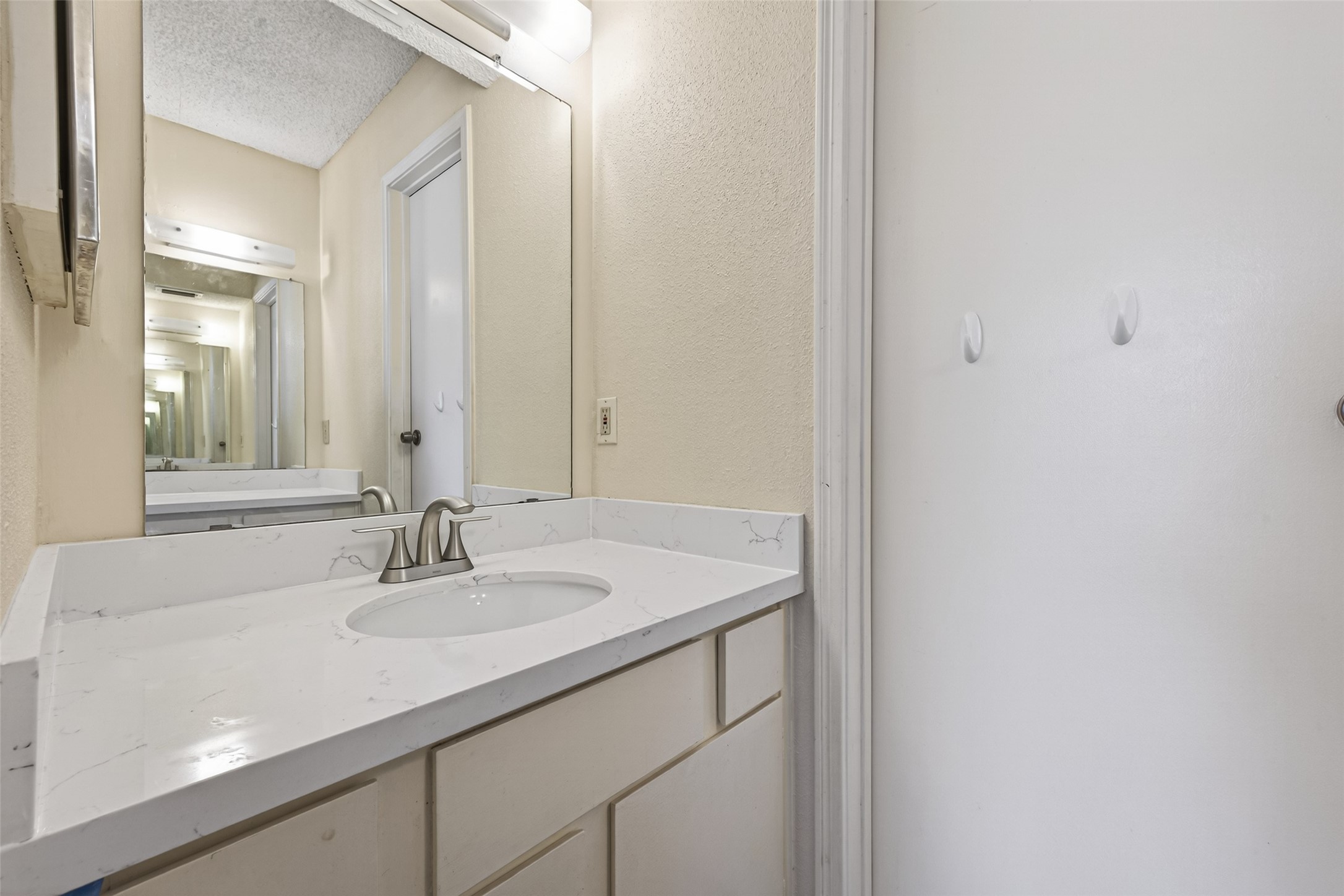 3100 Jeanetta Street, Unit 1004 Houston, TX 77063 - Photo 27 of 42 The well-lit vanity is thoughtfully separated from the bathing area, offering plenty of storage for a streamlined morning routine.
