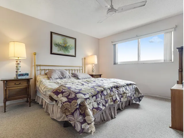 a bedroom with a bed and dresser with mirror