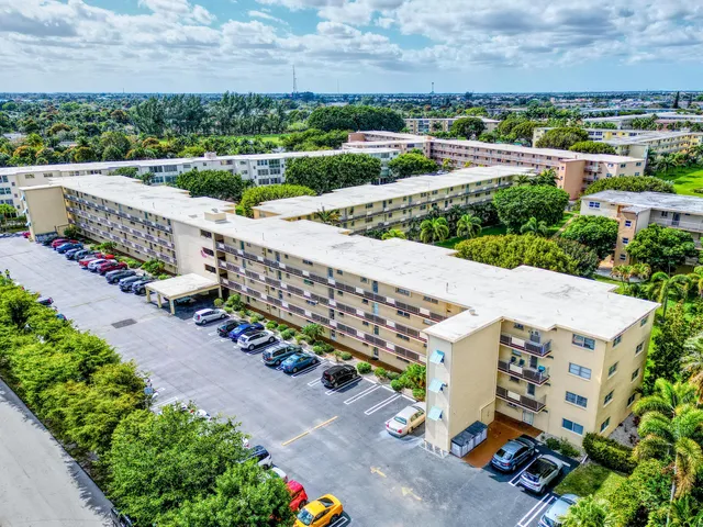 an aerial view of residential houses with outdoor space and trees all around
