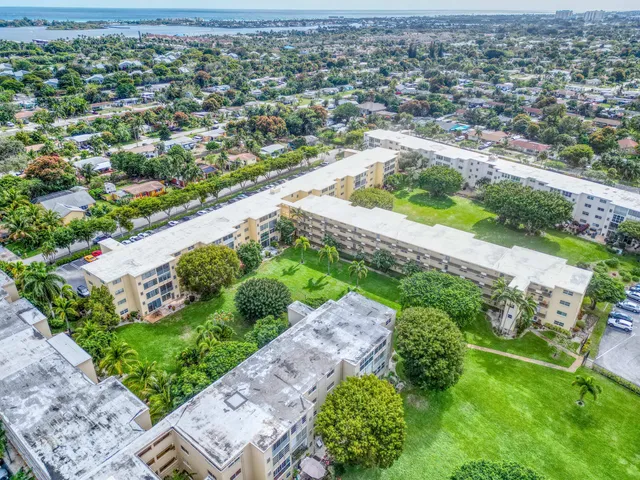 an aerial view of residential houses with yard and lake view