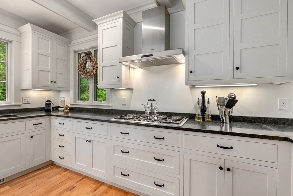 103 Conant Road Weston, MA 02493 - Photo 15 of 42 a kitchen with granite countertop white cabinets and white appliances