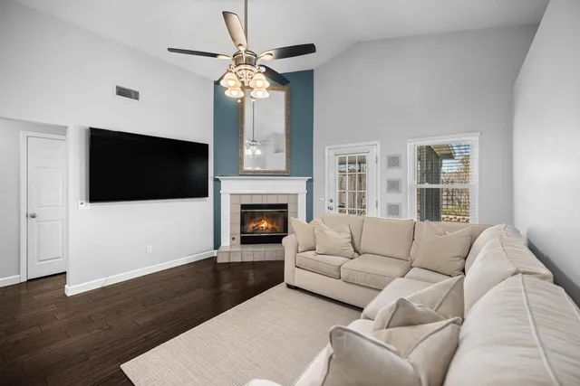 a kitchen with stainless steel appliances kitchen island granite countertop a refrigerator a stove a sink dishwasher and white cabinets with wooden floor