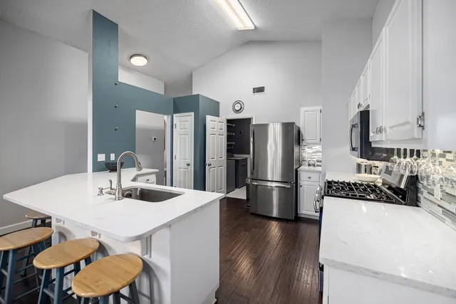 a kitchen with white cabinets and appliances