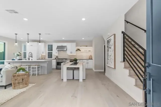 a large white kitchen with chairs a stove a sink and a refrigerator