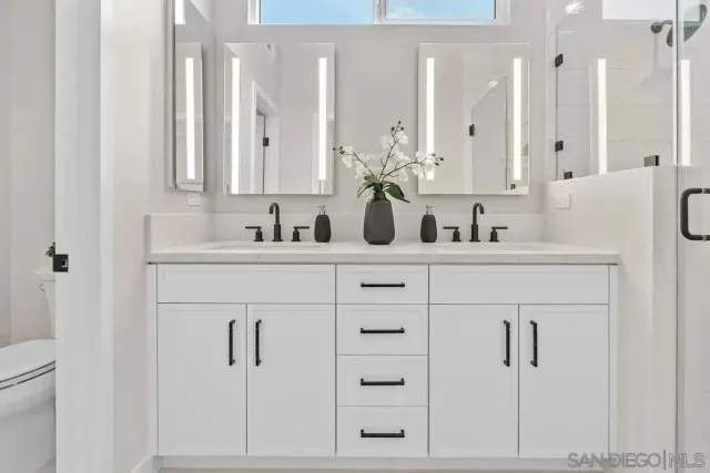 a bathroom with double vanity sink a mirror and vanity