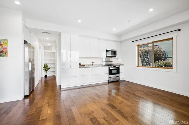 a view of a kitchen with microwave and wooden floor