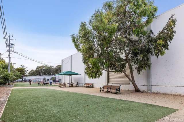 a garden with trees and outdoor seating