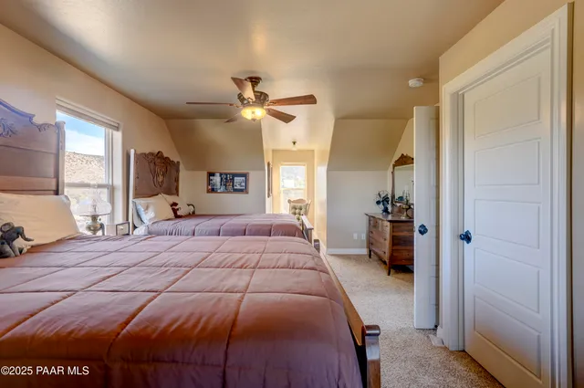 a bedroom with a large bed a chandelier and dresser