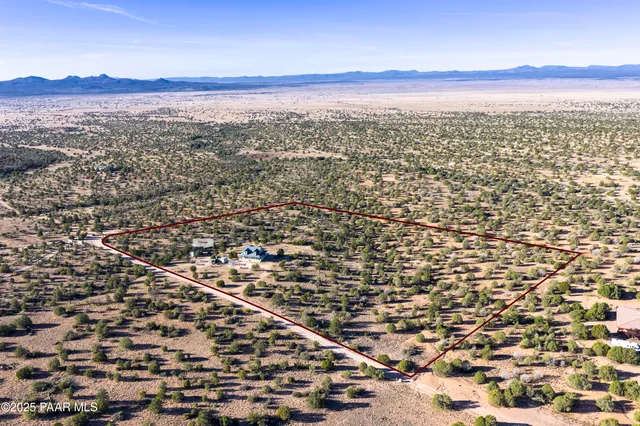 a view of a dry yard with mountains in the background