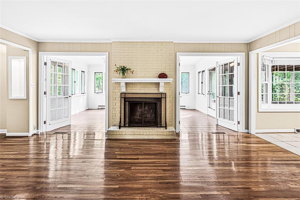 3903 Oakcliffe Road Greensboro, NC 27406 - Photo 17 of 42 The den offers a brick wood burning fireplace and hardwood flooring.