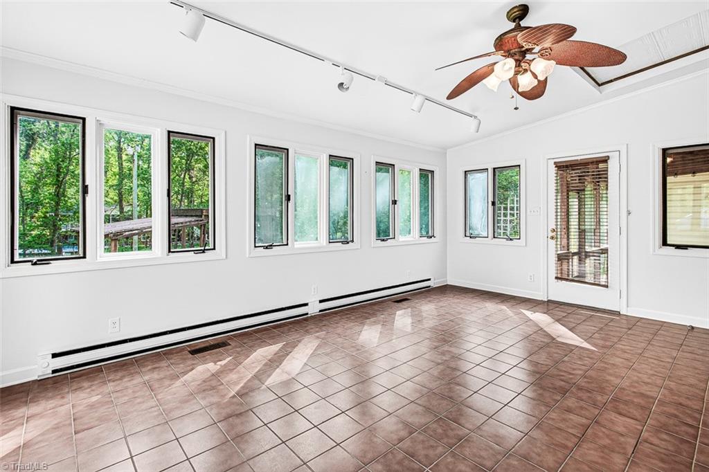 3903 Oakcliffe Road Greensboro, NC 27406 - Photo 19 of 42 Sunroom with ceramic tile flooring opens to the screen porch.