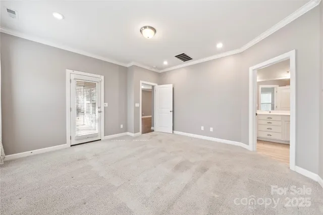 a view of an empty room with window and bathroom