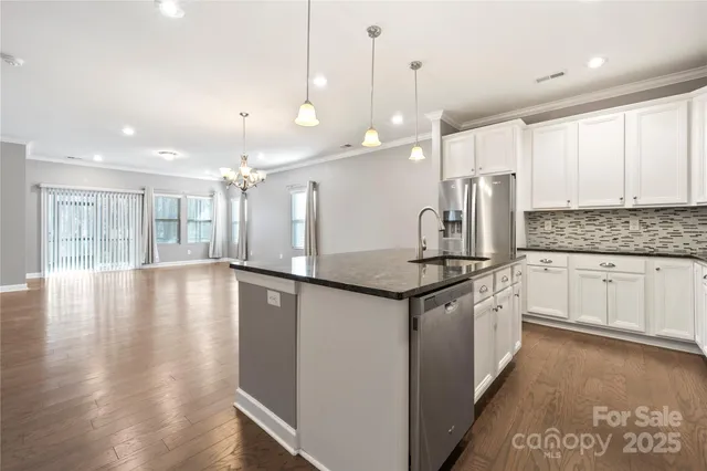 a large kitchen with stainless steel appliances granite countertop a stove a sink and a refrigerator