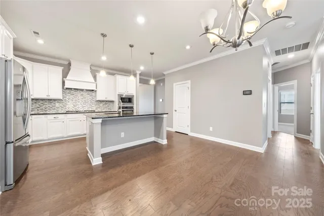 a large kitchen with kitchen island a sink stainless steel appliances and cabinets