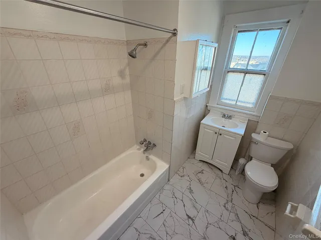 a bathroom with a tub toilet and a shower