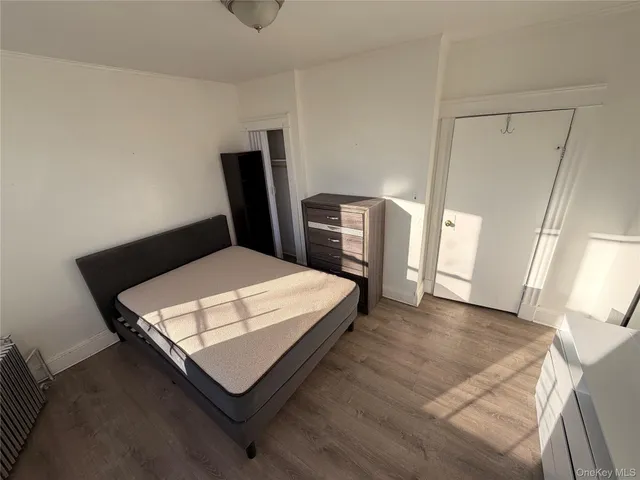 a bedroom with a bed a rug and a mirror