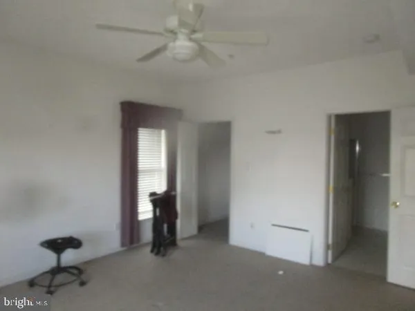 a view of an empty room with a chandelier fan