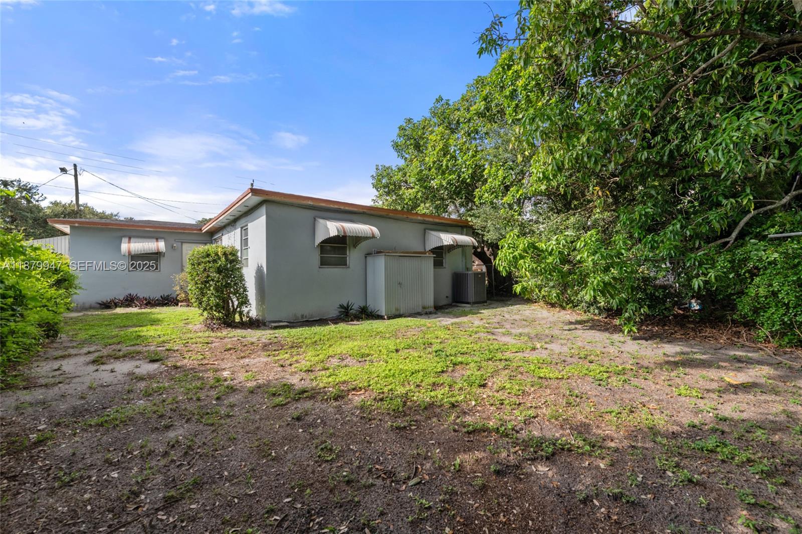 3265 Northwest 50th Street Miami, FL 33142 - Photo 12 of 17 a backyard of a house with large trees and plants