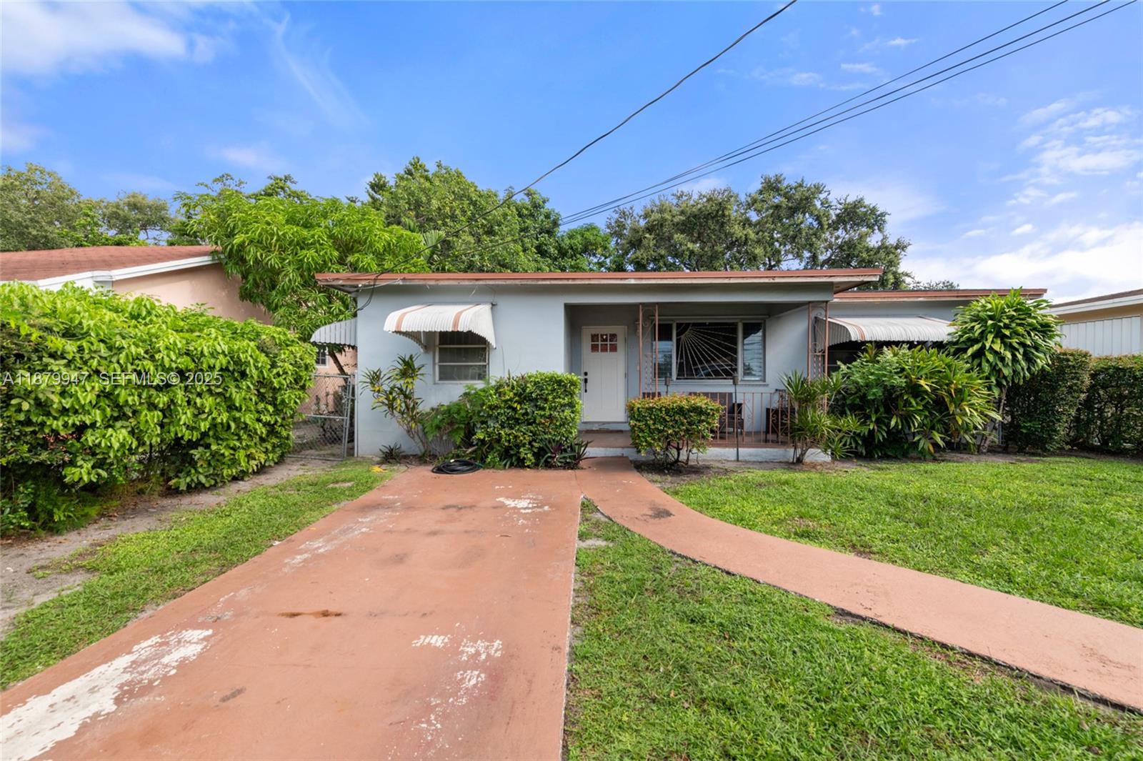 3265 Northwest 50th Street Miami, FL 33142 - Photo 2 of 17 a front view of a house with porch and garden