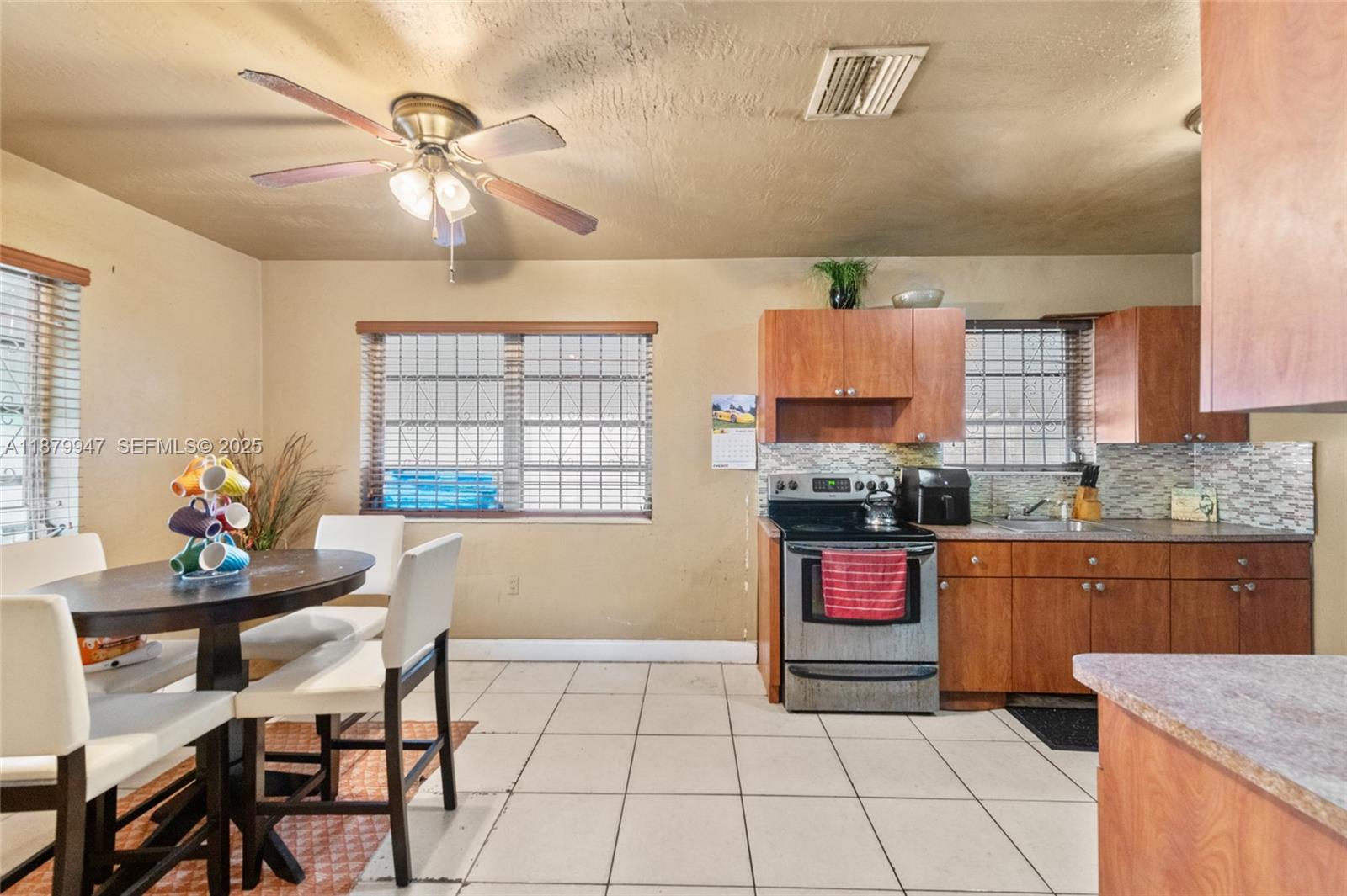 3265 Northwest 50th Street Miami, FL 33142 - Photo 7 of 17 a kitchen with stainless steel appliances granite countertop a stove a sink and a microwave